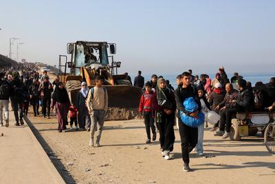 Displaced Palestinians making their way back on foot from the southern regions to their homes in the north via Al Rashid Road-stock-foto