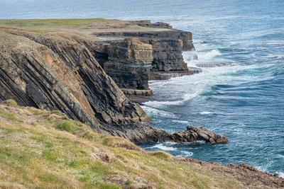 Wellen des Atlantiks, die auf die Klippen der Loophead-Halbinsel, Grafschaft Clare, Irland, prallen-stock-photo