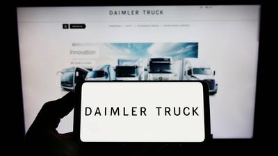 Person holding smartphone with logo of automotive company Daimler Truck Holding AG on screen. Stuttgart, Germany - 06-25-stock-foto