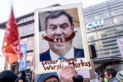 Markus S?der mit brauner AfD-Wurst, Schild bei Demo Sei die Brandmauer vor der CSU-Zentrale, Brandmauer zur AfD br?ckelt, M?nchen, 30. Januar 2025-stock-foto
