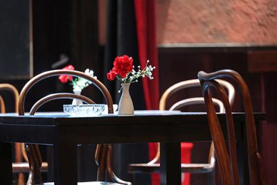 Rote Nelken in kleiner, weisser Vase im Buehnenbild des Theaterstueckes Keiner hat gesagt, dass Du ausziehen sollst von-stock-foto