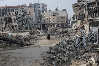 Internally Palestinians walk along a street among the rubble of destroyed buildings amid a ceasefire between Israel and Hamas, in Gaza City-stock-foto