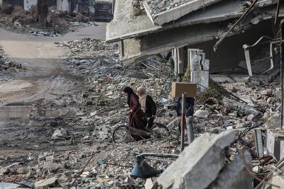 Internally Palestinians walk along a street among the rubble of destroyed buildings amid a ceasefire between Israel and Hamas, in Gaza City-stock-foto