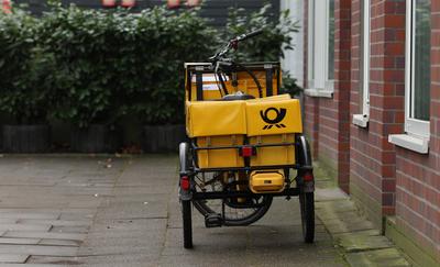 Das Fahrrad eines Briefzustellers steht vor einem Eingang. Barmbek Hamburg *** The bicycle of a letter carrier stands in-stock-foto