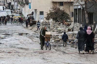 Palestinians carry boxes of aid provided by UNRWA, amid a ceasefire between Hamas and Israel, in Gaza City-stock-foto