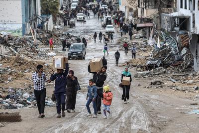 Palestinians carry boxes of aid provided by UNRWA, amid a ceasefire between Hamas and Israel, in Gaza City-stock-foto