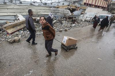 Palestinians carry boxes of aid provided by UNRWA, amid a ceasefire between Hamas and Israel, in Gaza City-stock-foto