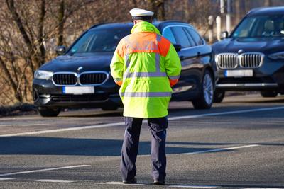Oberaudorf, Bavaria, Germany - February 6, 2025: Symbolic photo, A police officer in high-visibility clothing secures a-stock-foto