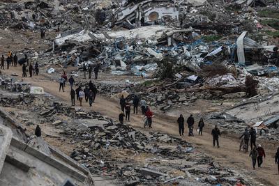 Palestinians inspect the destruction after the Israeli army withdrew from the Netzarim corridor, as part of a ceasefire agreement with Hamas in Gaza City-stock-photo
