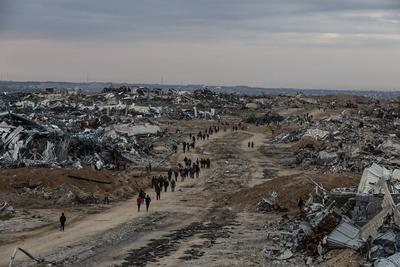 Palestinians inspect the destruction after the Israeli army withdrew from the Netzarim corridor, as part of a ceasefire agreement with Hamas in Gaza City-stock-photo
