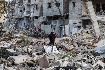 Palestinians walk along a street among the rubble of destroyed buildings amid a ceasefire between Israel and Hamas, in Gaza City-stock-foto