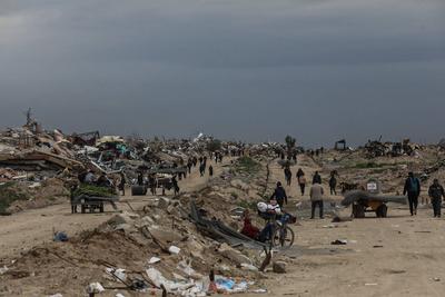 Palestinians inspect the destruction after the Israeli army withdrew from the Netzarim corridor, as part of a ceasefire agreement with Hamas in Gaza City-stock-photo