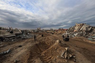Palestinians inspect the destruction after the Israeli army withdrew from the Netzarim corridor, as part of a ceasefire agreement with Hamas in Gaza City-stock-photo