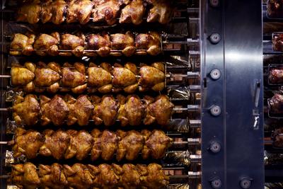 Brathähnchen drehen sich auf einem Hähnchengrill. Aktivisten der Tierschutzorganisation PETA forderten unlängst ein Sex--stock-foto