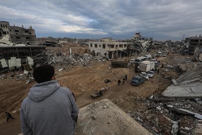 Palestinians inspect the destruction after the Israeli army withdrew from the Netzarim corridor, as part of a ceasefire agreement with Hamas in Gaza City-stock-photo