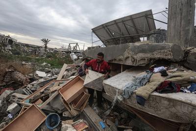 Palestinians inspect the destruction after the Israeli army withdrew from the Netzarim corridor, as part of a ceasefire agreement with Hamas in Gaza City-stock-photo