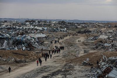 Palestinians inspect the destruction after the Israeli army withdrew from the Netzarim corridor, as part of a ceasefire agreement with Hamas in Gaza City-stock-photo