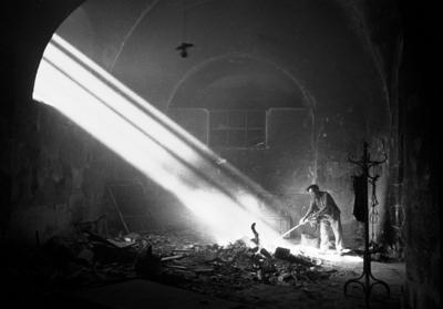 Zerst?rte B?cher Ein Mann schiebt verbrannte B?cher zusammen in einem Soltano Keller Alkazar in Toledo, Spanien um 1936.-stock-foto