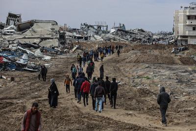 Palestinians inspect the destruction after the Israeli army withdrew from the Netzarim corridor, as part of a ceasefire agreement with Hamas in Gaza City-stock-photo
