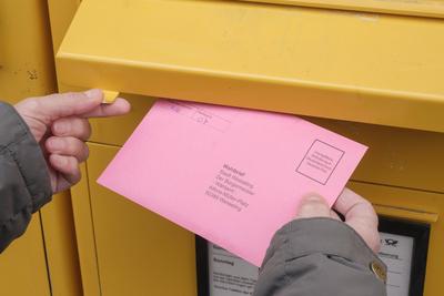 Hand wirft den Wahlbrief zur Briefwahl zur Bundestagswahl am 23.02.2025 in einen Briefkasten *** Hand drops the postal ballot letter for the Bundestag election on 23 February 2025 into a letterbox-stock-foto