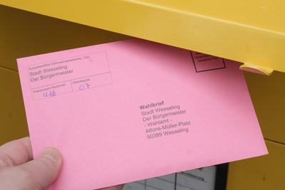 Hand wirft den Wahlbrief zur Briefwahl zur Bundestagswahl am 23.02.2025 in einen Briefkasten *** Hand drops the postal ballot letter for the Bundestag election on 23 February 2025 into a letterbox-stock-foto