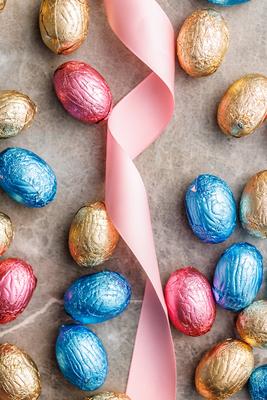 Easter chocolate eggs wrapped in aluminium foil on kitchen table. Top view. Easter chocolate eggs wrapped in aluminium f-stock-foto