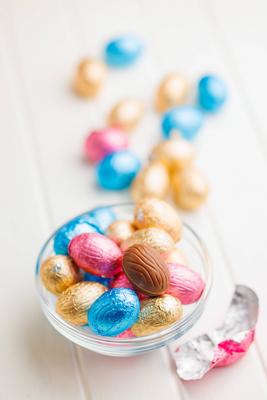 Easter chocolate eggs wrapped in aluminium foil in bowl on white table. Easter chocolate eggs wrapped in aluminium foil-stock-foto