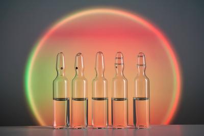 Ampoules for injection against the background of a bright orange circle. Several ampoules for injection with medicines a-stock-foto
