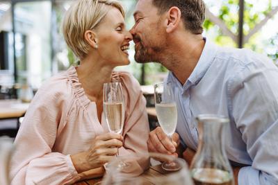 Close up of beautiful couple in restaurant, on romantic date. Wife and husband kissing, having a romantic moment at rest-stock-photo