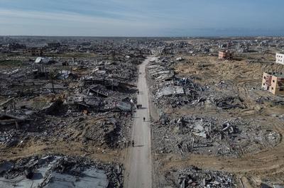 An aerial view taken with a drone shows internally displaced Palestinians walking along a street among the rubble of destroyed buildings amid a ceasefire between Israel and Hamas, in Rafah-stock-foto