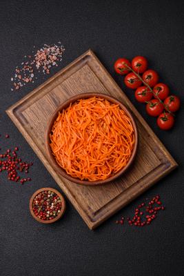 Tasty spicy Korean carrot with spices and herbs on a dark concrete background Tasty spicy Korean carrot with spices and-stock-foto