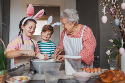 Grandmother with grandchildren preparing traditional easter meals, baking cakes and sweets. Passing down family recipes,-stock-foto