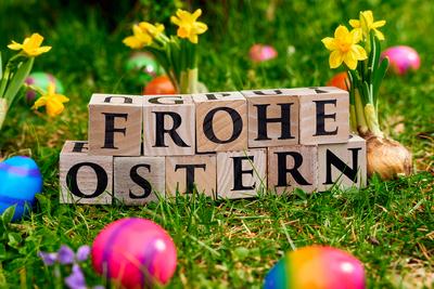Augsburg, Bavaria, Germany - March 28, 2024: Happy Easter! Greeting written with wooden letter cubes in a green meadow w-stock-foto