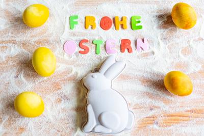 3 March 2024: Baking at Easter concept, Easter bunny baking tin on a worktop with flour and Easter eggs with text letter-stock-photo