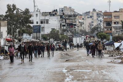 Palestinians walk through rubble during severe weather conditions in the Al-Rimal neighborhood in central Gaza City-stock-foto