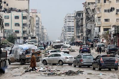 Palestinians walk through rubble during severe weather conditions in the Al-Rimal neighborhood in central Gaza City-stock-foto