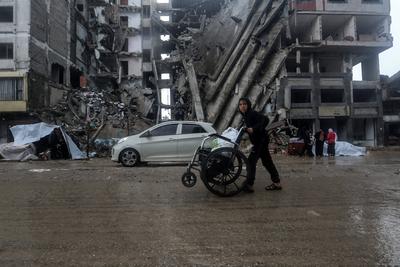 Palestinians walk through rubble during severe weather conditions in the Al-Rimal neighborhood in central Gaza City-stock-foto