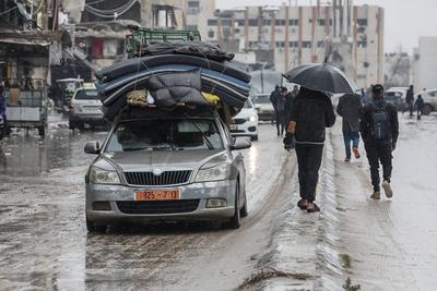 Palestinians walk through rubble during severe weather conditions in the Al-Rimal neighborhood in central Gaza City-stock-foto