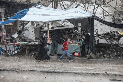 Palestinians walk through rubble during severe weather conditions in the Al-Rimal neighborhood in central Gaza City-stock-foto