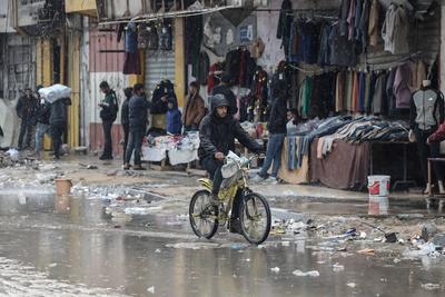 Palestinians walk through rubble during severe weather conditions in the Al-Rimal neighborhood in central Gaza City-stock-foto