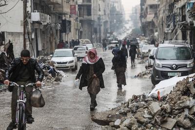 Palestinians walk through rubble during severe weather conditions in the Al-Rimal neighborhood in central Gaza City-stock-foto