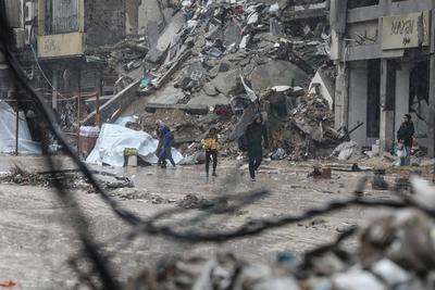 Palestinians walk through rubble during severe weather conditions in the Al-Rimal neighborhood in central Gaza City-stock-foto
