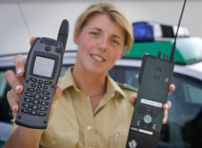 Eine Polizistin haelt das neue Digitalfunkgeraet l neben einem alten Funkgeraet der Bundespolizei-stock-foto