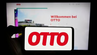 Person holding cellphone with logo of German mail order company Otto GmbH Co KG in front of webpage. Stuttgart, Germany-stock-foto