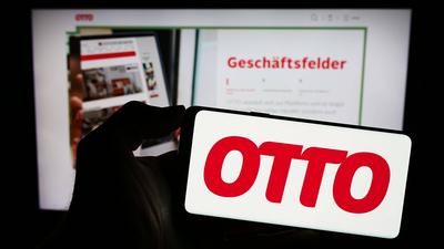 Person holding mobile phone with logo of German mail order company Otto GmbH Co KG. Stuttgart, Germany - 11-14-2023: Per-stock-foto