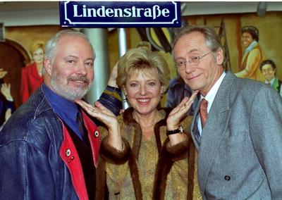 15 Jahre Lindenstra?e. Mutter Beimer mit ihren beiden Ehem?nnern unter dem ber?hmten Lindenstrassenschild. Bill Mockrid-stock-foto