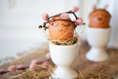 8 February 2023: Easter egg in egg cup with crown of branches and face. Easter concept *** Osterei in Eierbecher mit Kro-stock-photo