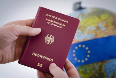 Ein deutscher Reisepass wird vor einen Globus gehalten.Berlin, 08.02.2018. Berlin Deutschland *** A German passport is-stock-foto