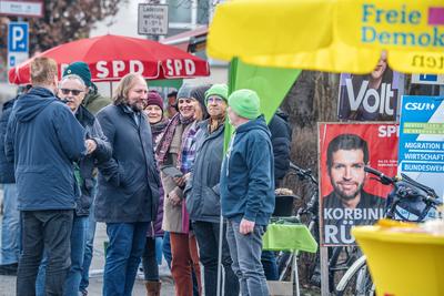 Letzter Tag Wahlkampf: Toni Hofreiter am Wahlkampfstand der GR?NEN, umgeben von den St?nden der anderen Parteien wie SPD und FDP, Neubiberg bei M?nchen, 22. Februar 2025-stock-foto