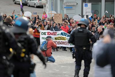 Die Polizei sichert den Demonstrationszug und h?lt linke und rechte Symphatisanten auseinander. In Einsiedeln, dem Schweizer Wohnort der deutschen Kanzlerkandidatin der Alternative f?r Deutschland (AfD), fand am 22. Februar 2025 eine Demonstration gegen die AfD und Weidel statt.-stock-foto
